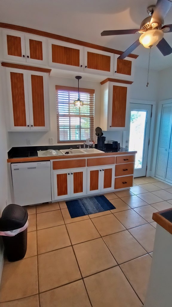 kitchen with a healthy amount of sunlight, dishwasher, light tile patterned floors, and pendant lighting