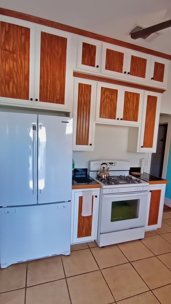 kitchen with light tile patterned flooring and white appliances