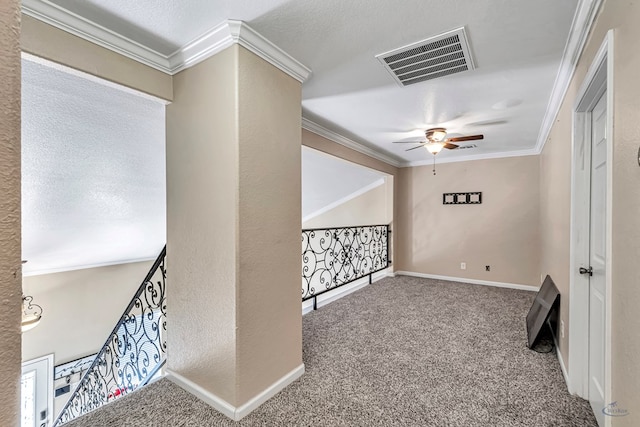 interior space featuring carpet flooring, ornamental molding, and a textured ceiling