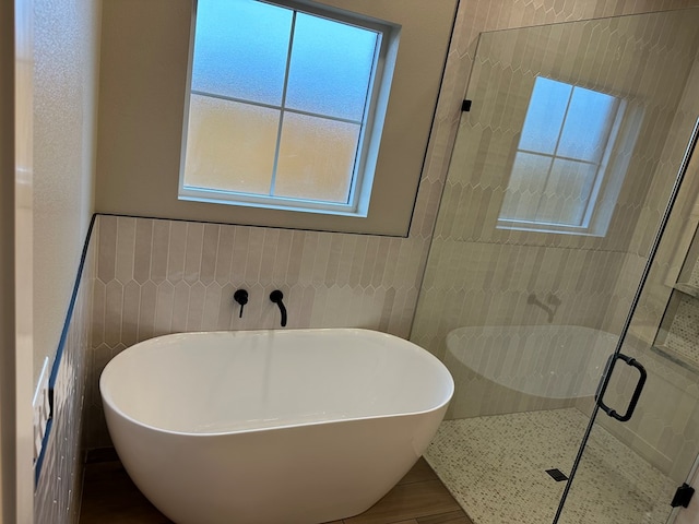 bathroom featuring tile walls and plus walk in shower