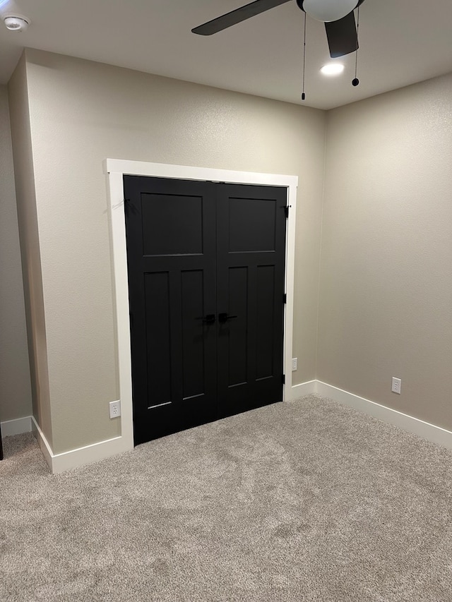 carpeted spare room with ceiling fan