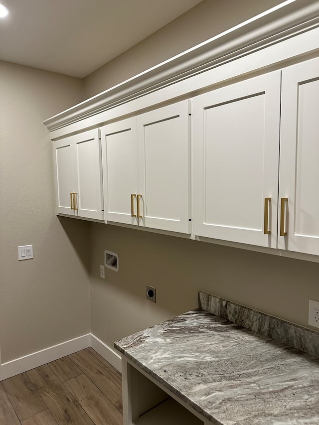 laundry room with washer hookup, hookup for an electric dryer, cabinets, and wood-type flooring