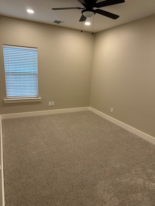 spare room featuring ceiling fan and carpet