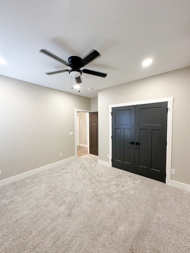 unfurnished bedroom featuring carpet, a closet, and ceiling fan