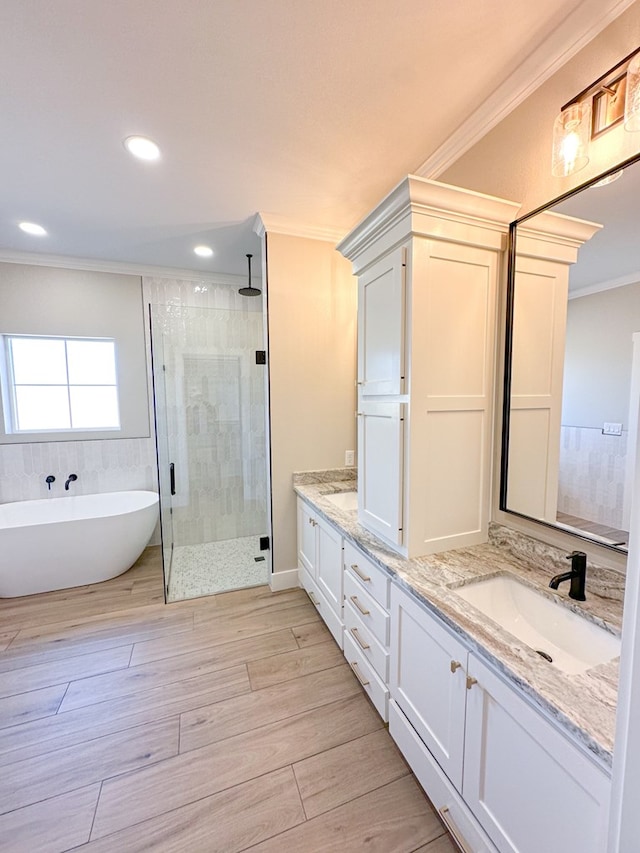 bathroom with vanity, ornamental molding, and independent shower and bath