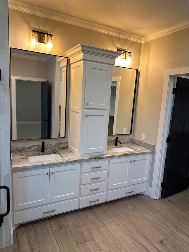 bathroom featuring hardwood / wood-style flooring, vanity, and ornamental molding