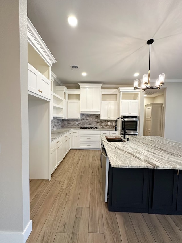 kitchen with ornamental molding, stainless steel appliances, sink, pendant lighting, and white cabinets