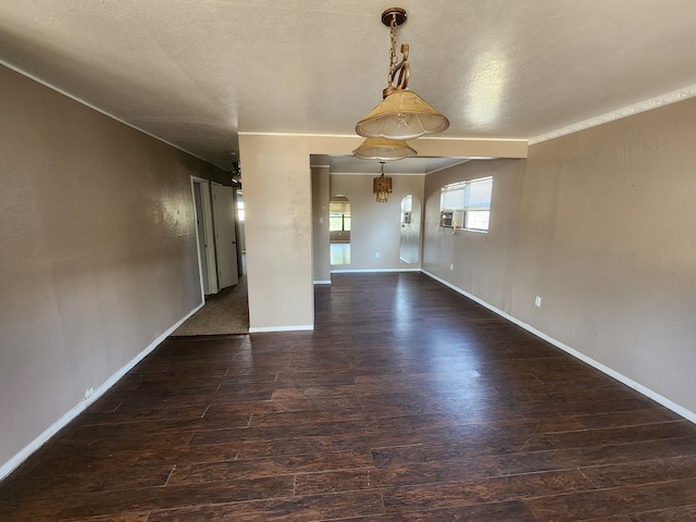 empty room featuring a textured ceiling and dark hardwood / wood-style floors