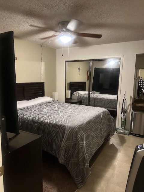 bedroom with ceiling fan, a textured ceiling, and tile patterned floors