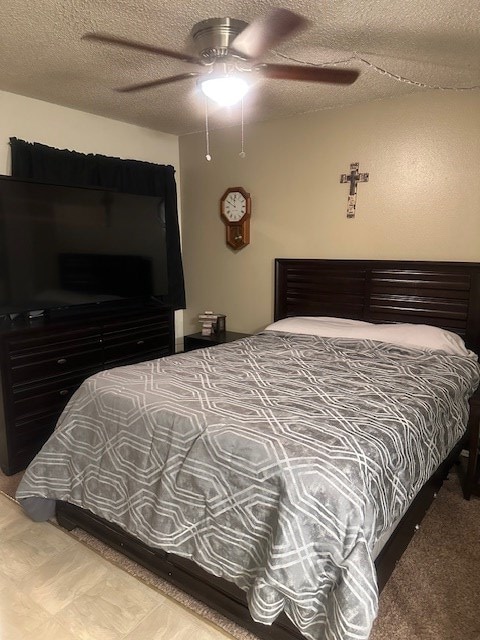 bedroom with a textured ceiling and ceiling fan