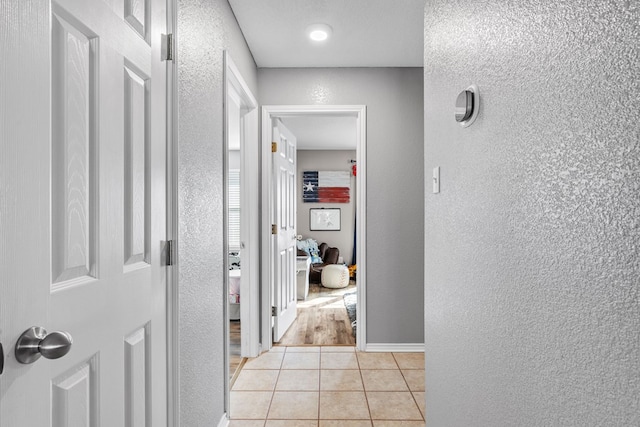 hall featuring light tile patterned floors