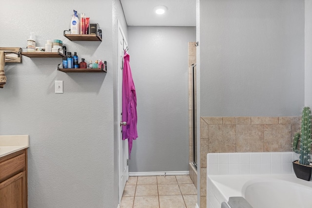 bathroom featuring tile patterned flooring, vanity, and shower with separate bathtub