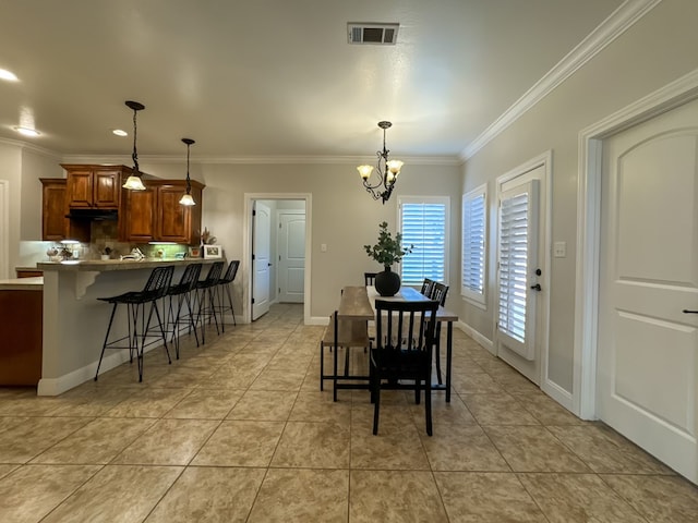 tiled dining space featuring a notable chandelier and ornamental molding