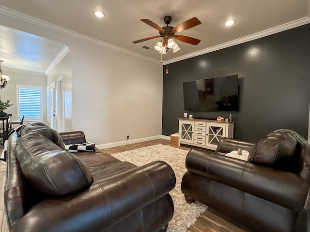 living room with hardwood / wood-style floors, ceiling fan with notable chandelier, and crown molding