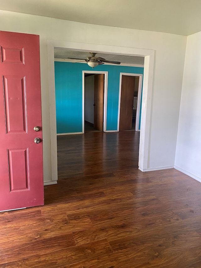 empty room featuring ceiling fan and dark wood-type flooring