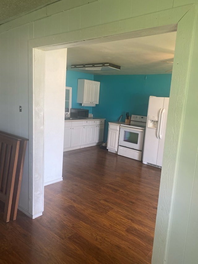 kitchen featuring dark hardwood / wood-style flooring, white appliances, white cabinetry, and sink