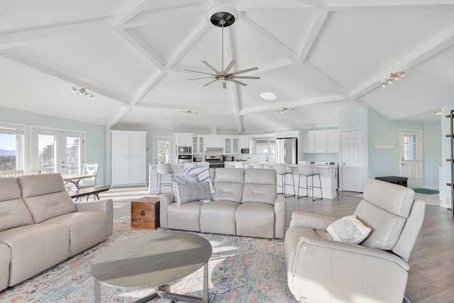 living area featuring beamed ceiling, rail lighting, high vaulted ceiling, and wood finished floors