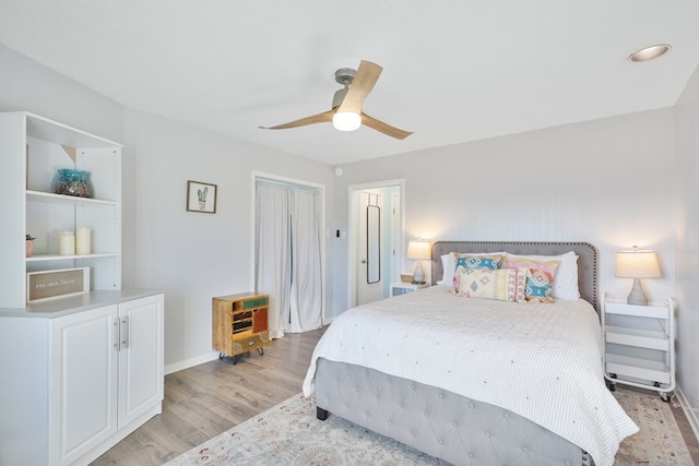 bedroom with a ceiling fan, a closet, light wood finished floors, and baseboards