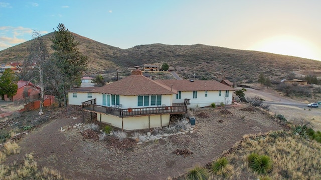 back of property featuring a deck with mountain view