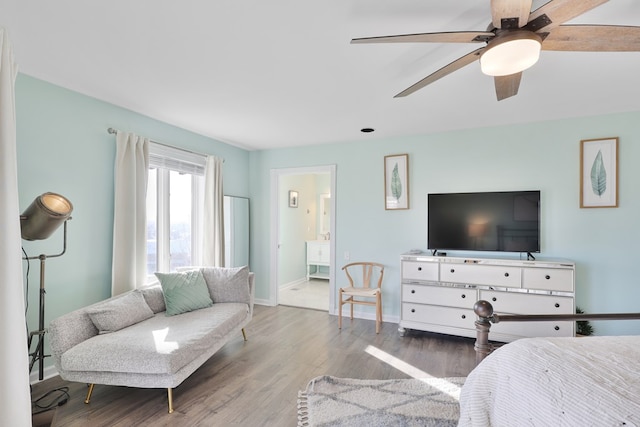 bedroom featuring a ceiling fan, ensuite bath, wood finished floors, and baseboards