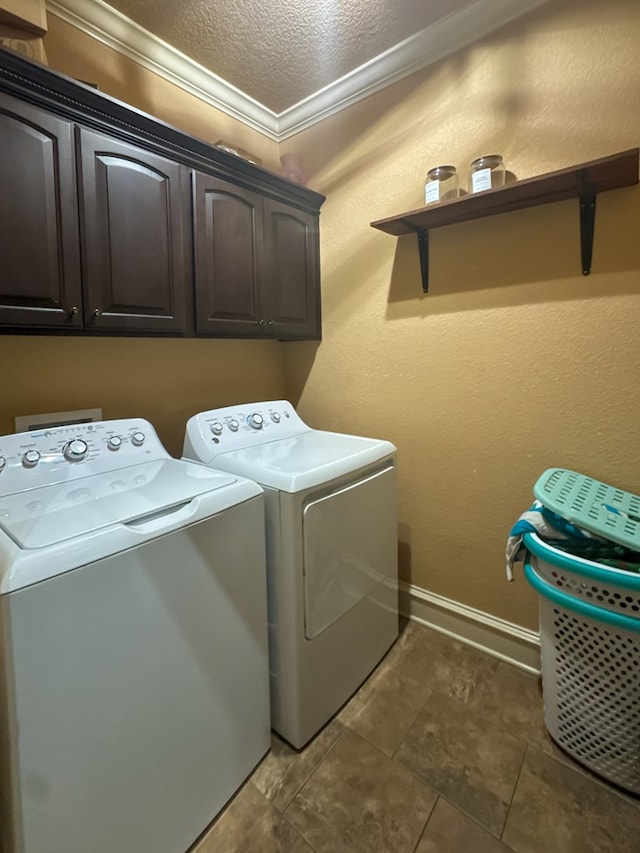 clothes washing area with cabinets, ornamental molding, washer and dryer, and a textured ceiling