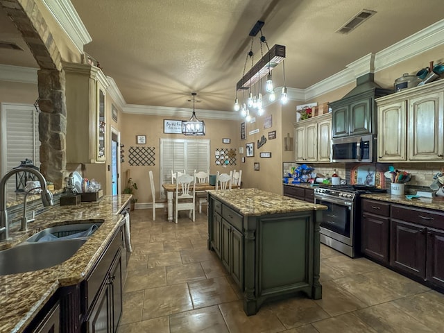 kitchen with appliances with stainless steel finishes, a center island, sink, and light stone counters