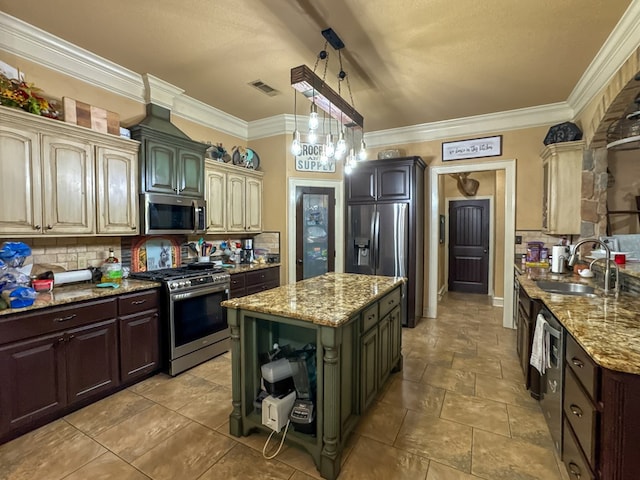 kitchen with appliances with stainless steel finishes, sink, and cream cabinetry