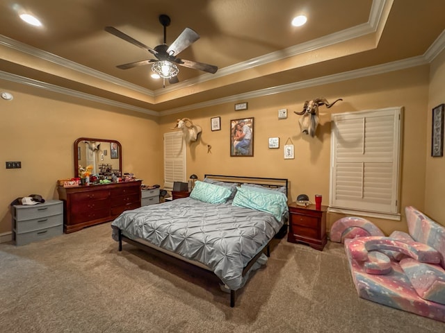 carpeted bedroom with a raised ceiling, ornamental molding, and ceiling fan