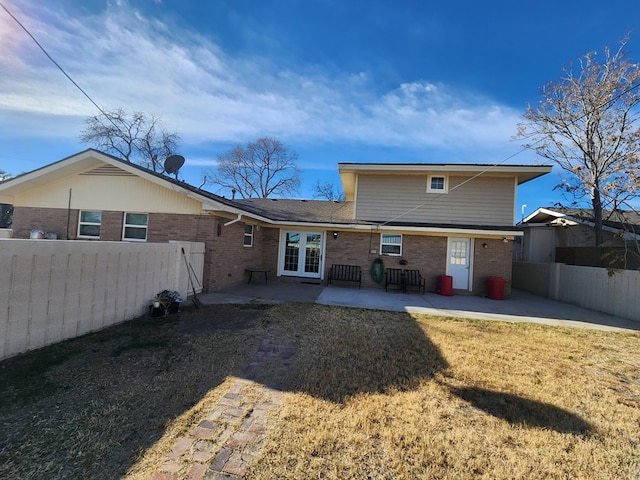 rear view of property featuring a yard, french doors, and a patio