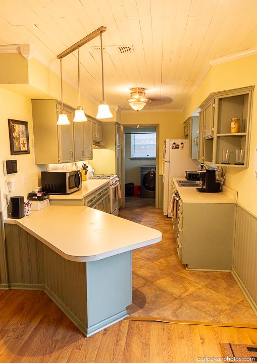 kitchen featuring decorative light fixtures, stove, kitchen peninsula, and washer / clothes dryer