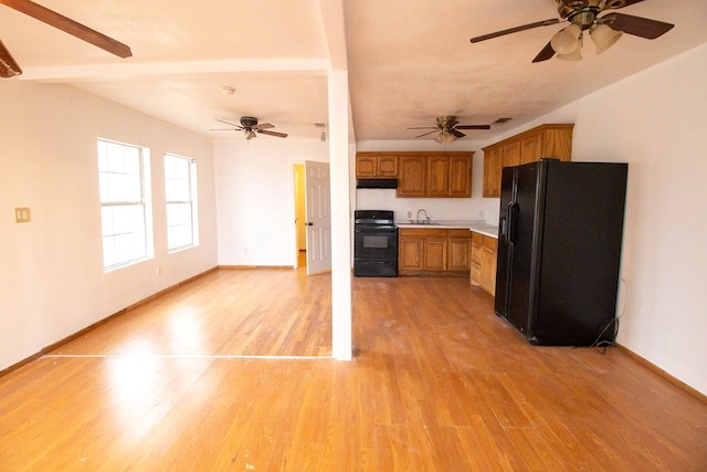 kitchen featuring sink, black appliances, ceiling fan, and light wood-type flooring