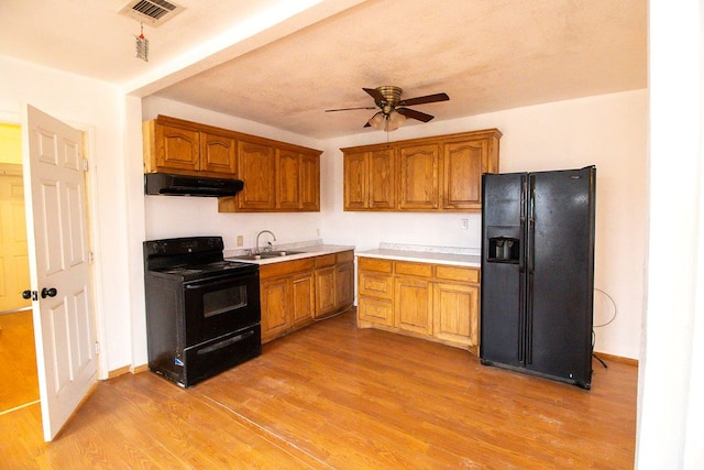 kitchen with ceiling fan, sink, light hardwood / wood-style flooring, and black appliances