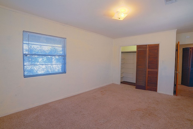 unfurnished bedroom featuring carpet flooring, a closet, and ornamental molding