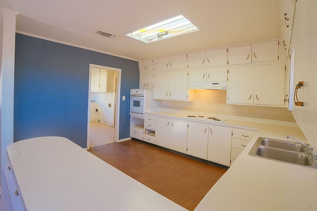 kitchen with dark parquet flooring, white cabinetry, sink, and white appliances