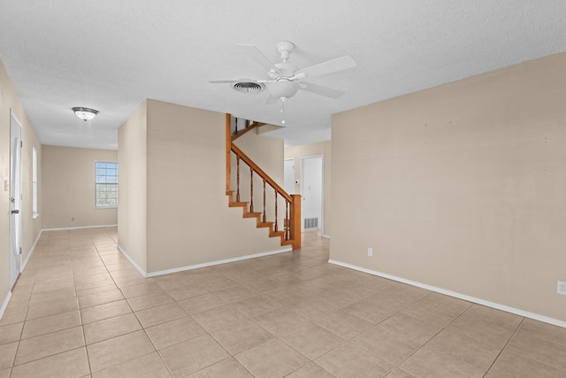 unfurnished room featuring ceiling fan, light tile patterned flooring, and a textured ceiling