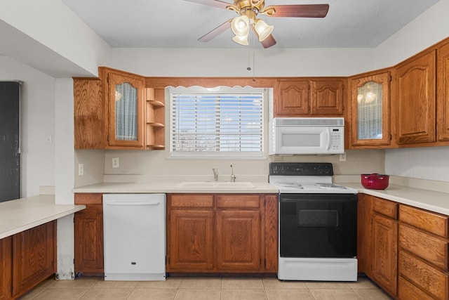 kitchen featuring white appliances, sink, ceiling fan, light tile patterned floors, and a textured ceiling