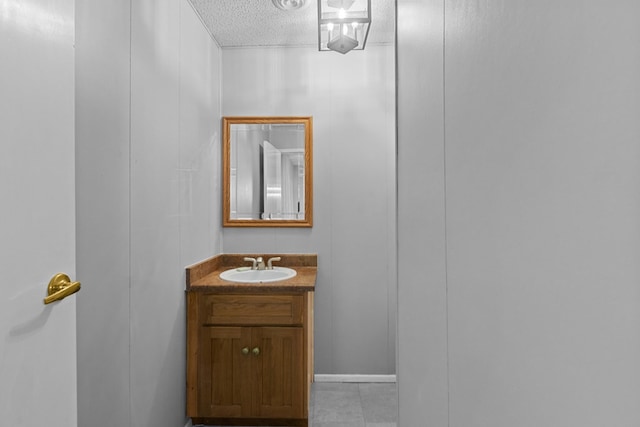 bathroom with tile patterned floors, vanity, and a textured ceiling