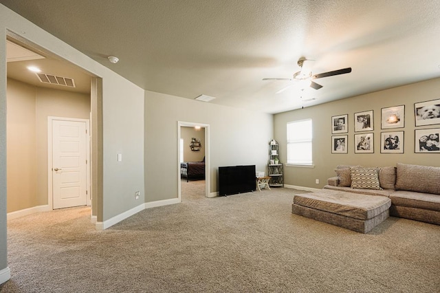 carpeted living room featuring visible vents, ceiling fan, a textured ceiling, and baseboards