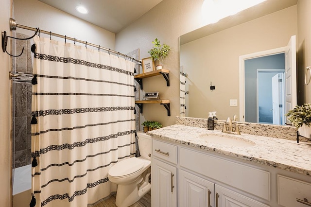 bathroom featuring toilet, curtained shower, and vanity