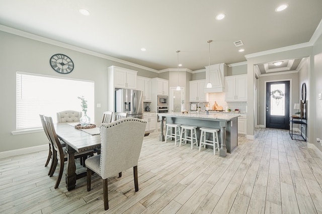 dining room with light wood finished floors, baseboards, visible vents, and a wealth of natural light