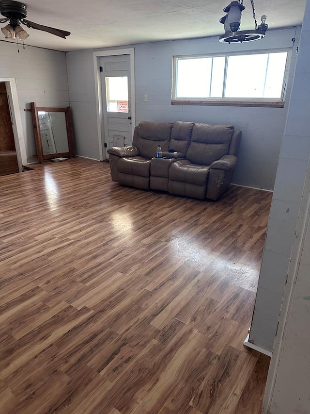 living room with dark hardwood / wood-style flooring, ceiling fan, and plenty of natural light