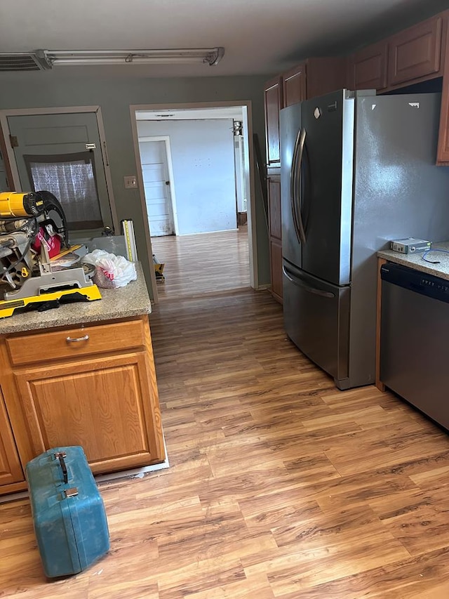 kitchen featuring appliances with stainless steel finishes and light hardwood / wood-style flooring