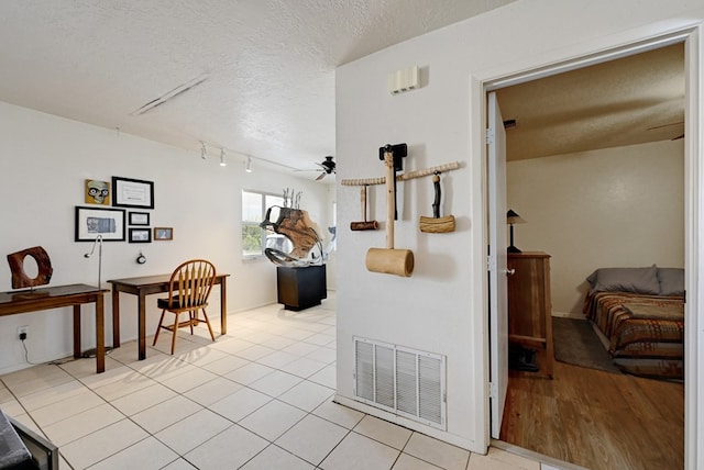 hallway featuring a textured ceiling and light tile patterned flooring