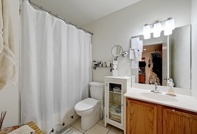 bathroom with toilet, vanity, a textured ceiling, and tile patterned floors