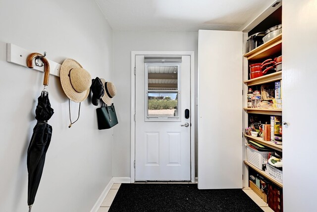 doorway to outside with light tile patterned flooring