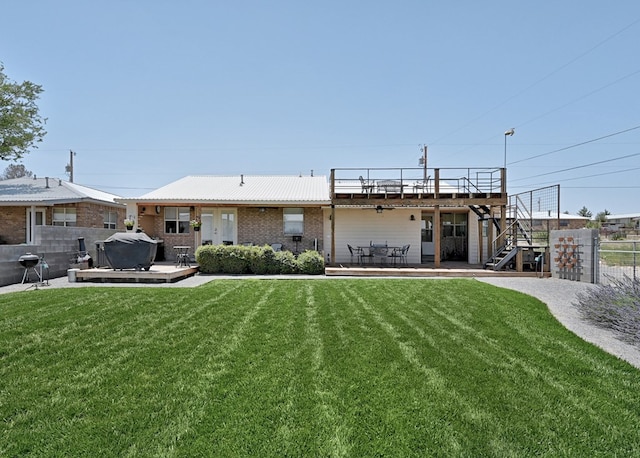 back of property featuring a jacuzzi, a deck, a patio area, and a lawn