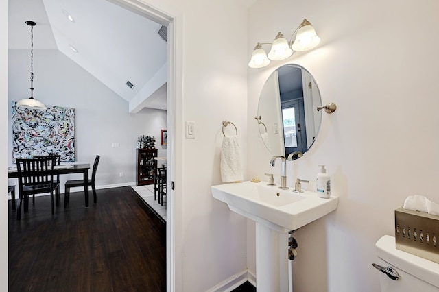 bathroom featuring hardwood / wood-style floors, toilet, sink, and vaulted ceiling