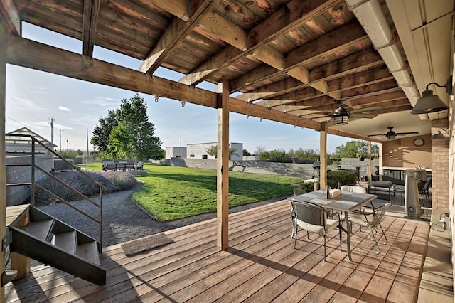 wooden deck with ceiling fan and a yard