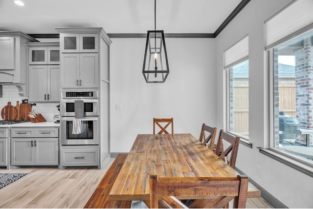 interior space featuring light wood finished floors, baseboards, and ornamental molding