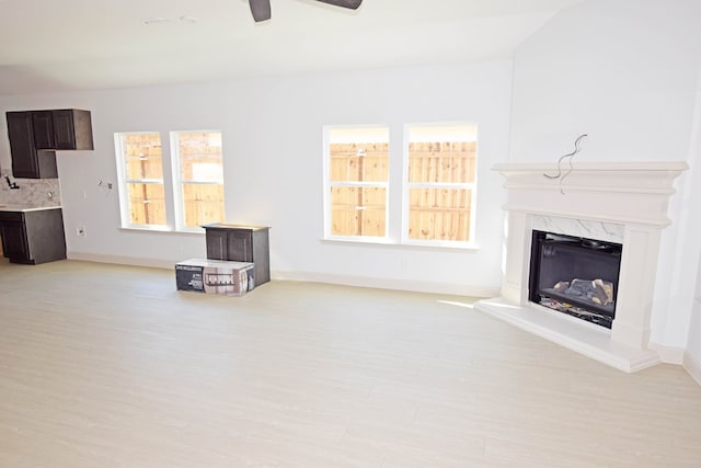 living room featuring a high end fireplace and ceiling fan